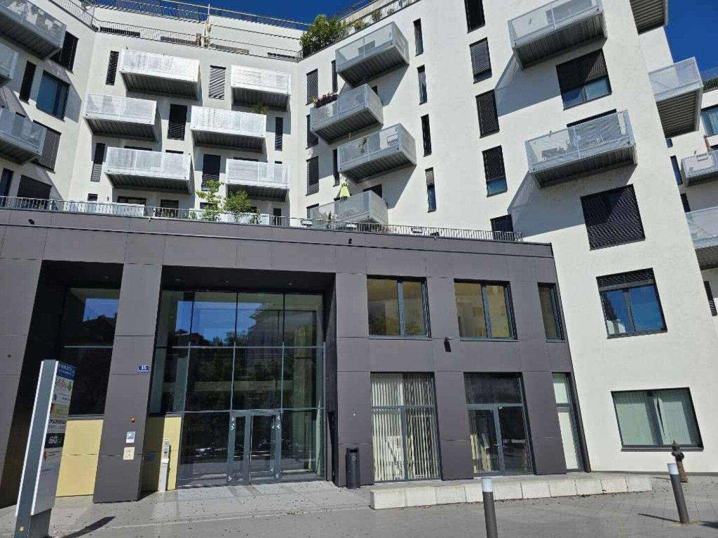 Moderne Wohnanlage mit zahlreichen Balkonen, großen Fenstern und zeitgenössischer Architektur.
