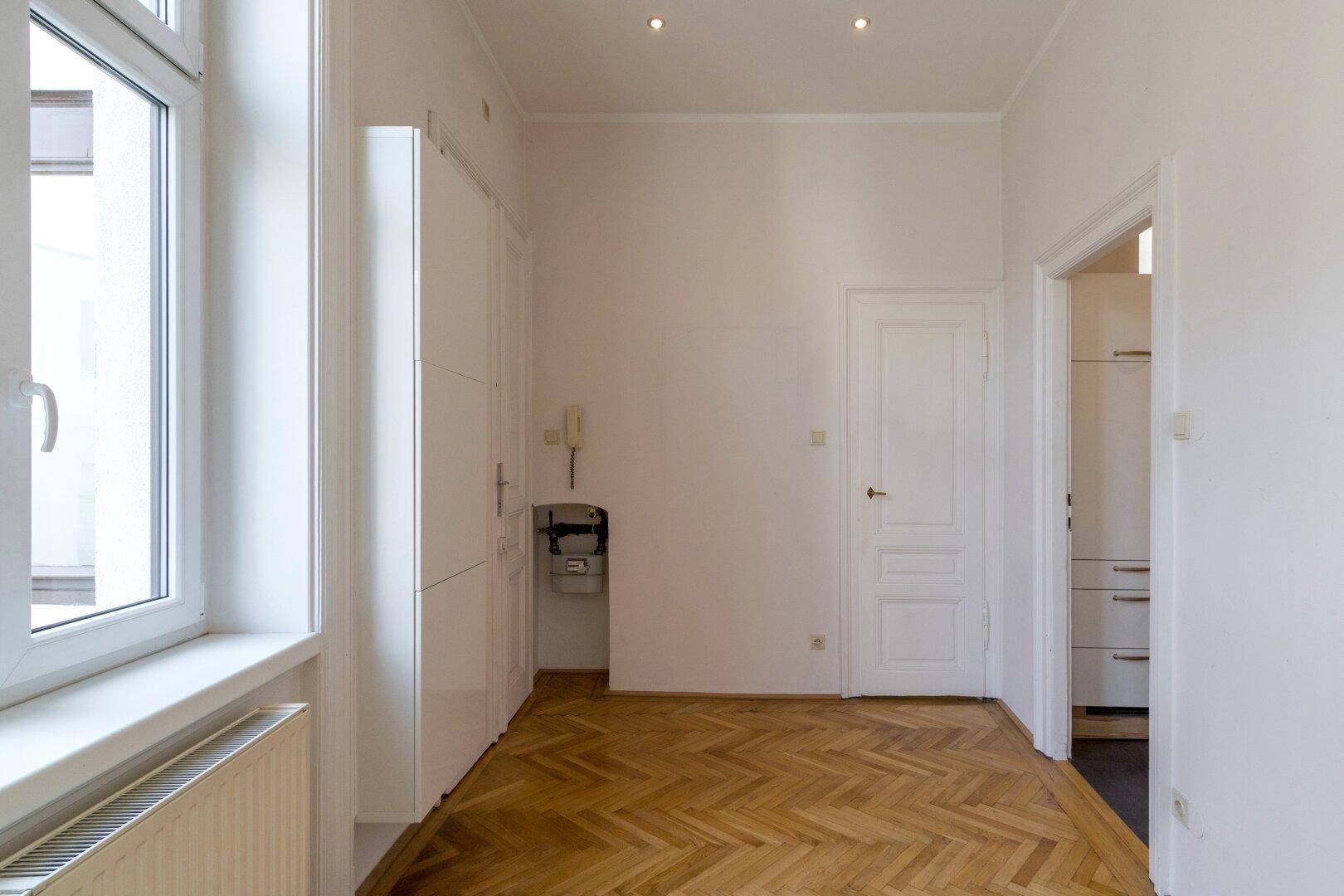 Heller Eingangsbereich oder Flur mit integrierten Schränken und Fischgrätparkett.