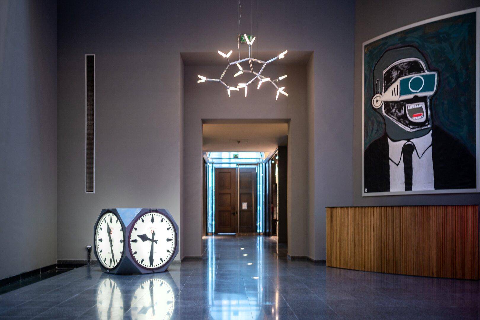 Elegante Lobby mit glänzendem Steinboden, moderner Beleuchtung und zeitgenössischer Kunst.