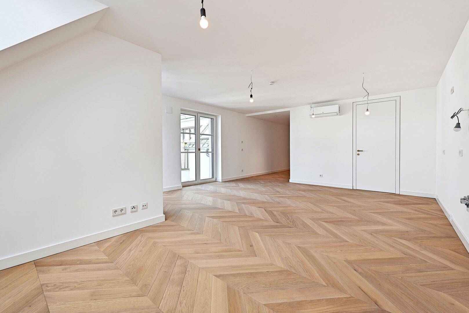Geräumiges, helles Zimmer mit elegantem Fischgrätparkett und moderner Klimaanlage.