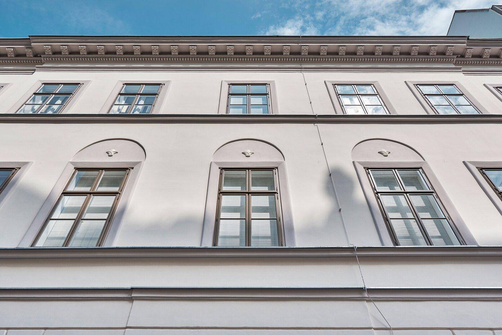 Detailansicht der Fenster und der klassischen Architektur der historischen Gebäudefassade.