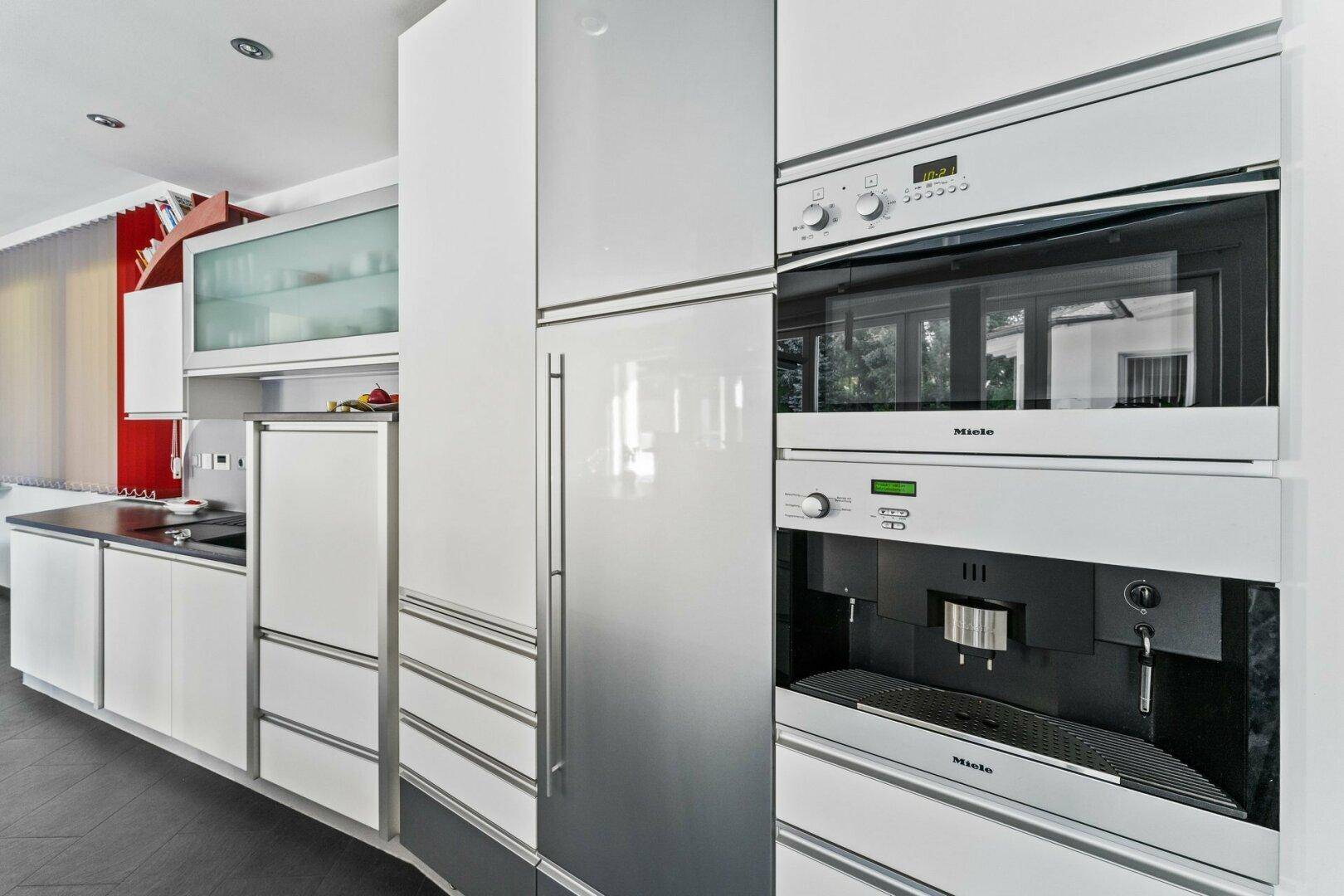 Hochwertige Miele-Einbaugeräte in der modernen Küche, inklusive Backofen und Kaffeemaschine.