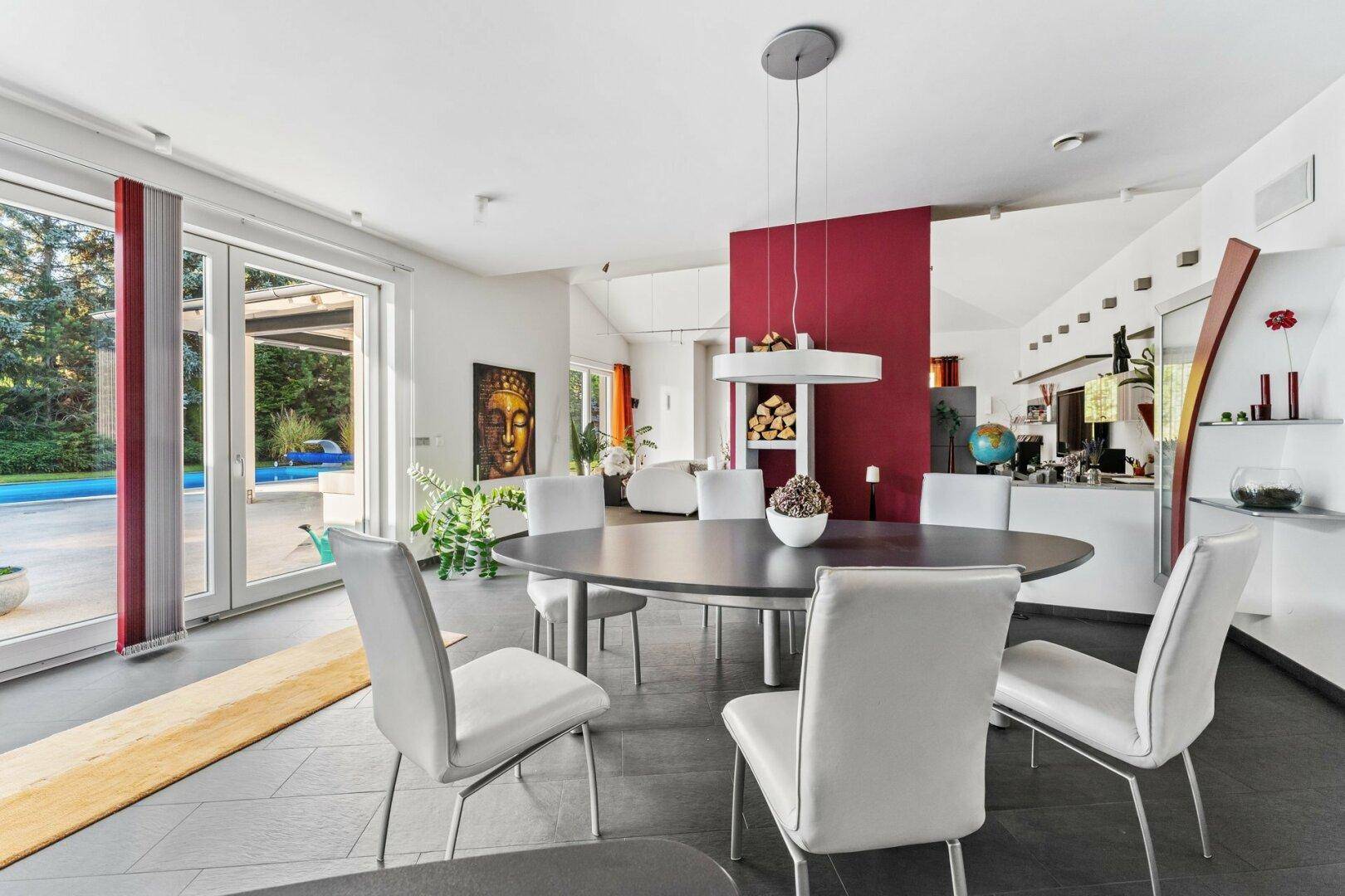 Eleganter Essbereich mit großem Tisch, modernen Stühlen und direktem Zugang zum Pool.