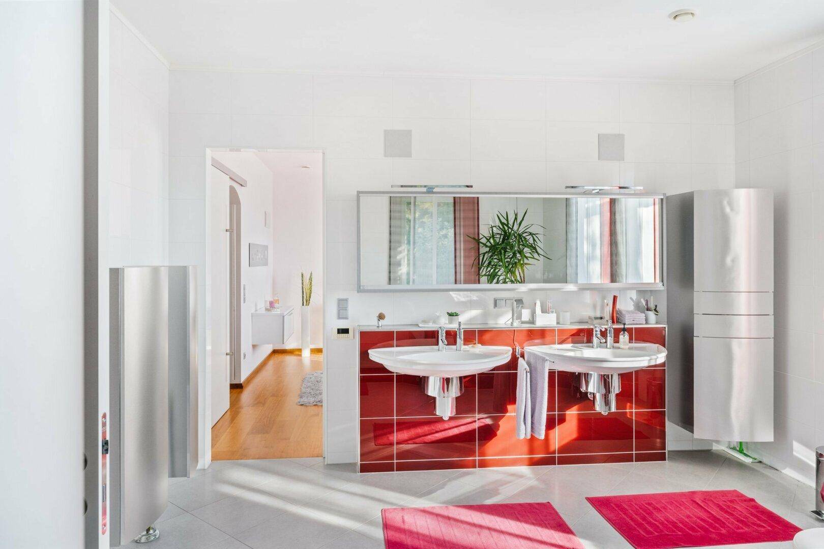Modernes Badezimmer mit Doppelwaschbecken, großem Spiegel und roten Fliesenakzenten.