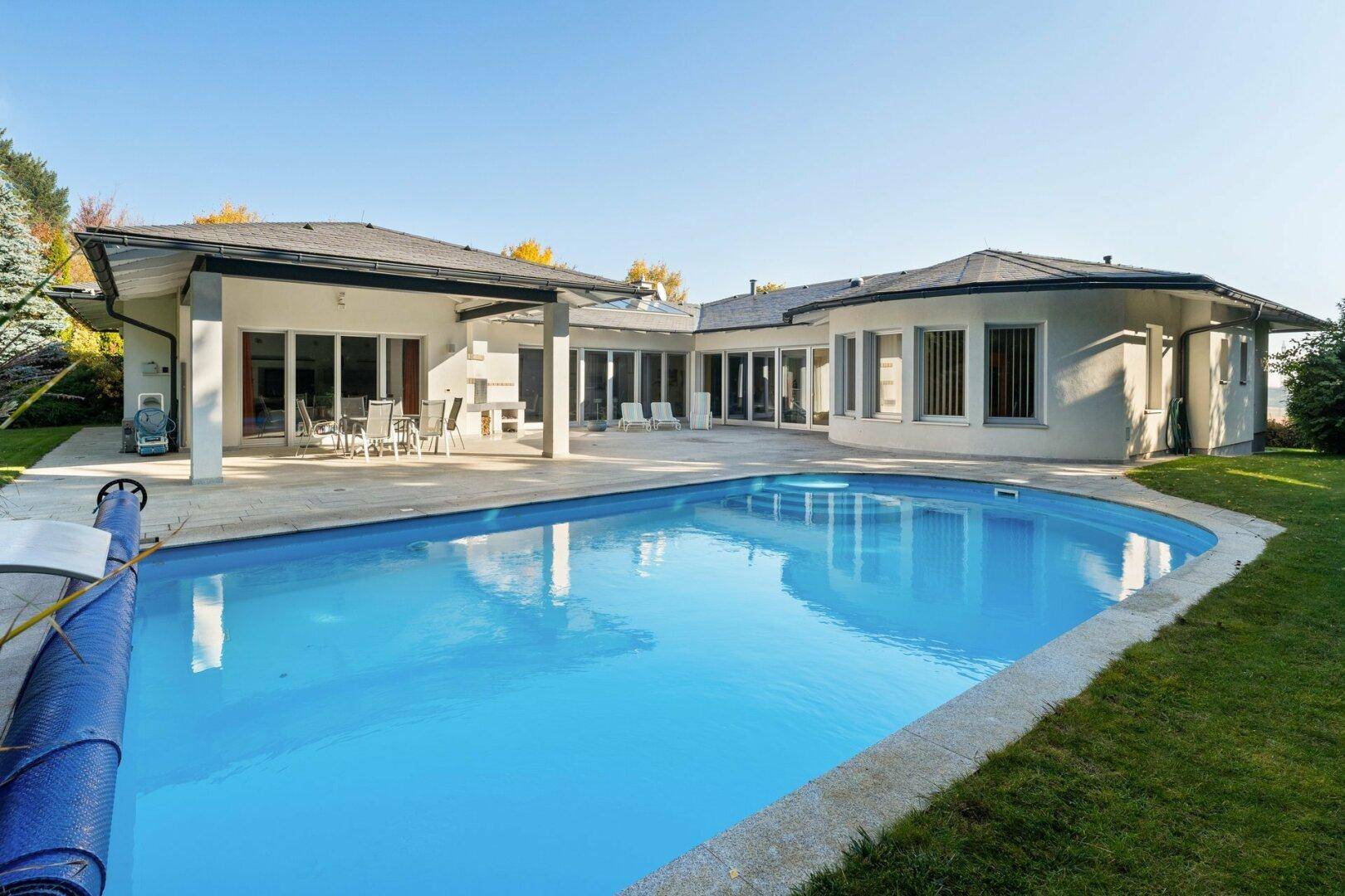 Weitläufiger Poolbereich mit großem Schwimmbecken und umliegender Terrasse.