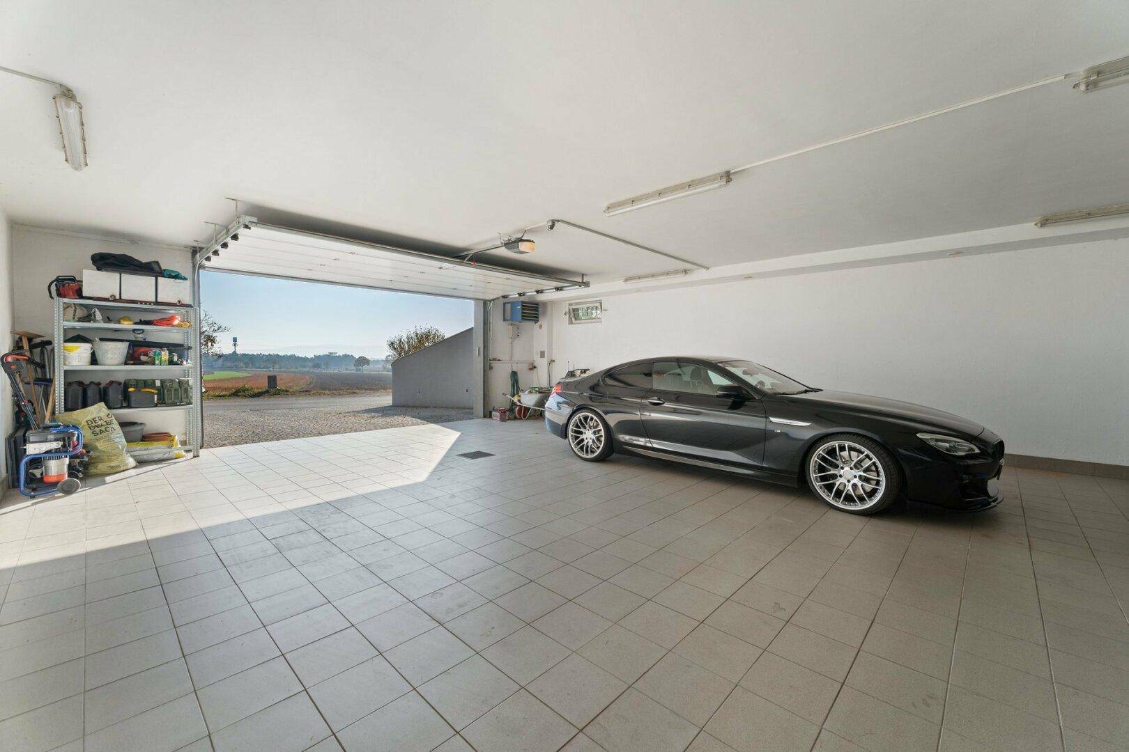 Geräumige Tiefgarage mit Fliesenboden und direktem Zugang ins Freie.