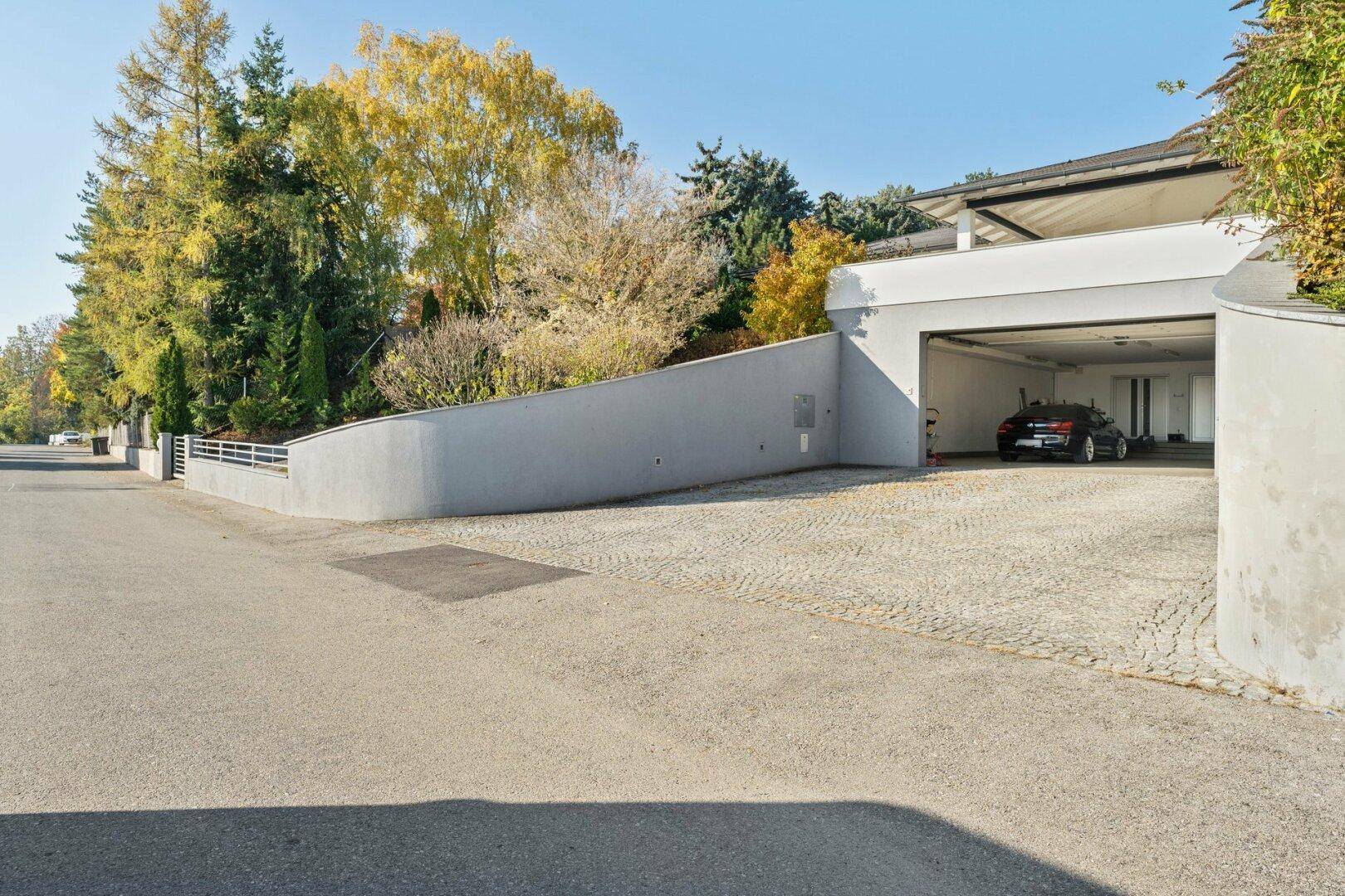 Zufahrt zur Tiefgarage mit gepflastertem Bereich und moderner Architektur.