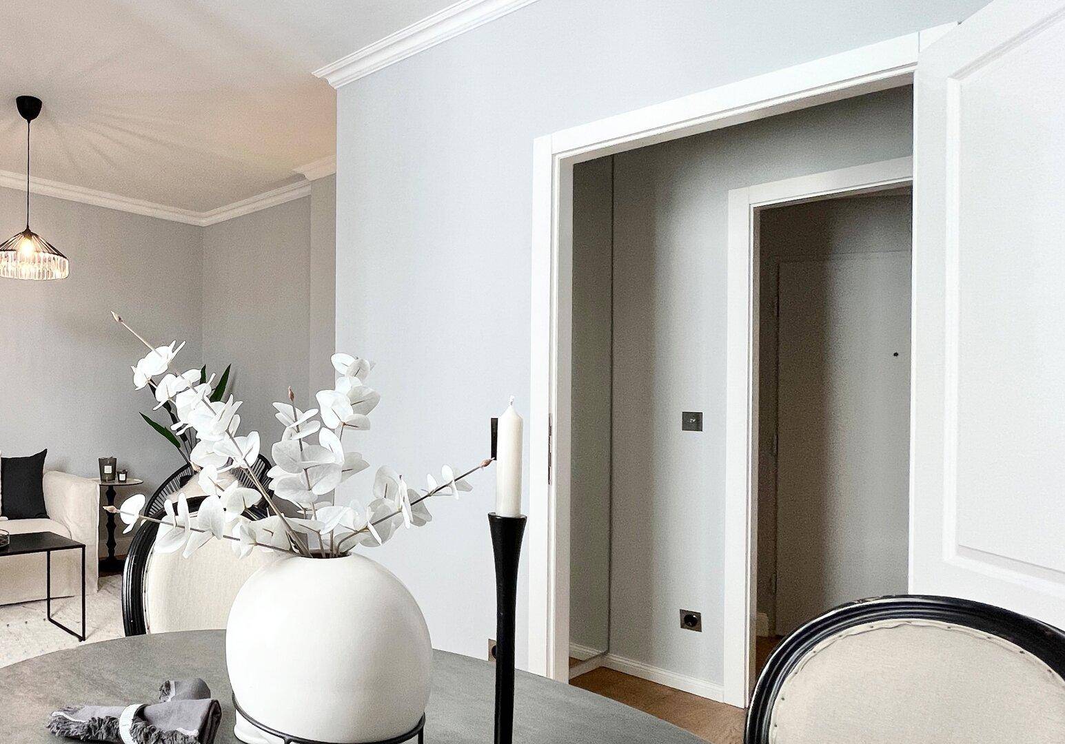 Essbereich mit elegantem Tisch und Stühlen, offen zum Wohnzimmer und mit Blick auf den Flur.