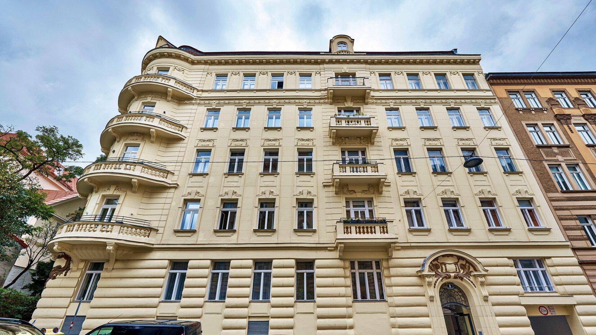 Prächtige Fassade eines historischen Gebäudes mit zahlreichen Fenstern und Balkonen.