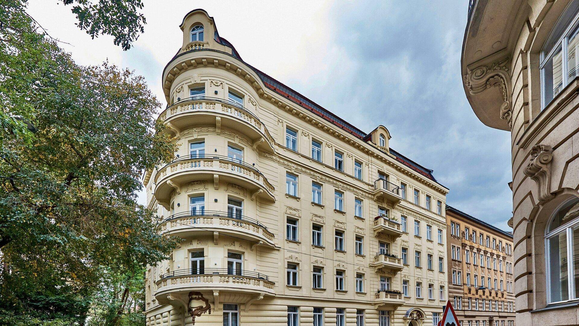 Historisches Eckgebäude mit reich verzierten Balkonen und klassischer Architektur.