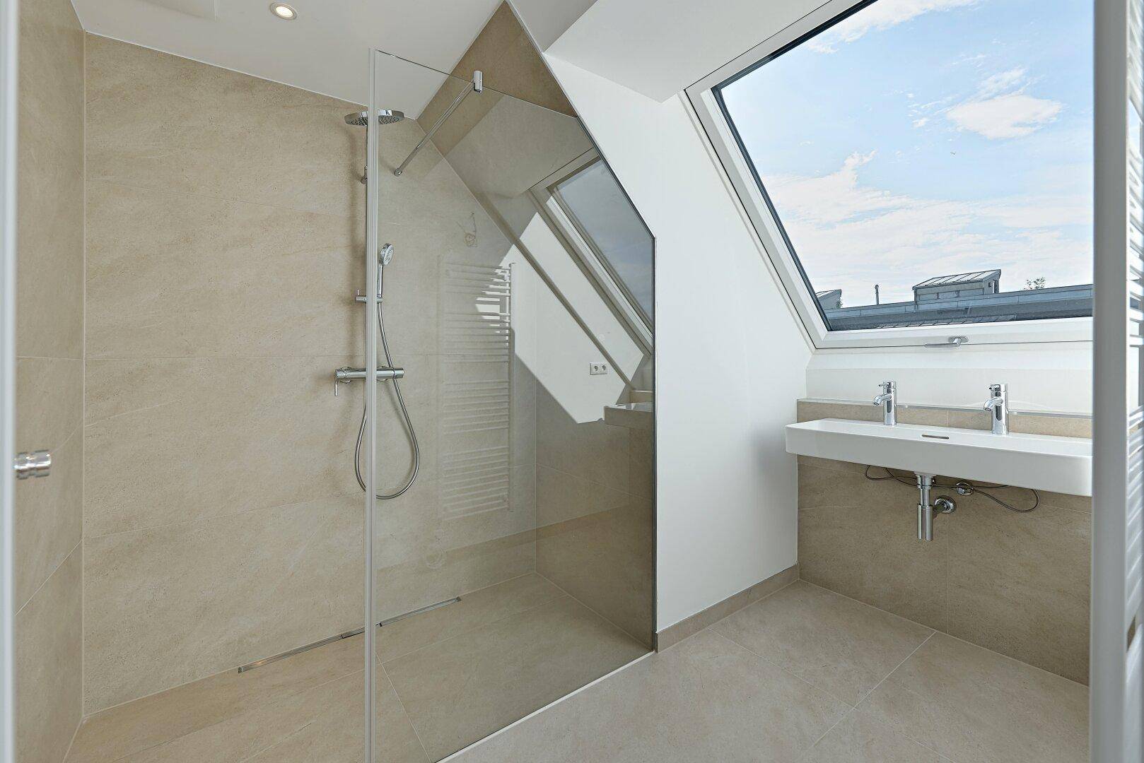 Modernes Badezimmer mit begehbarer Dusche, Doppelwaschbecken und Dachfenstern für viel Licht.