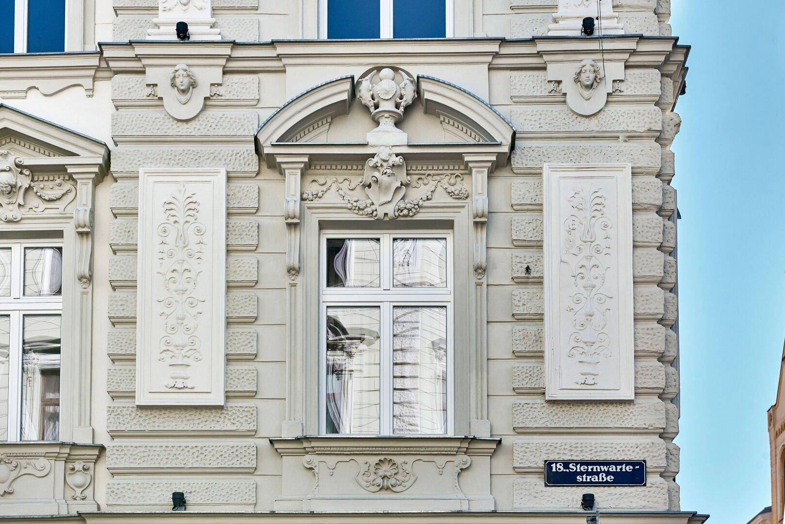 Detailansicht der historischen Fassade mit kunstvollen Verzierungen und Fenstern.
