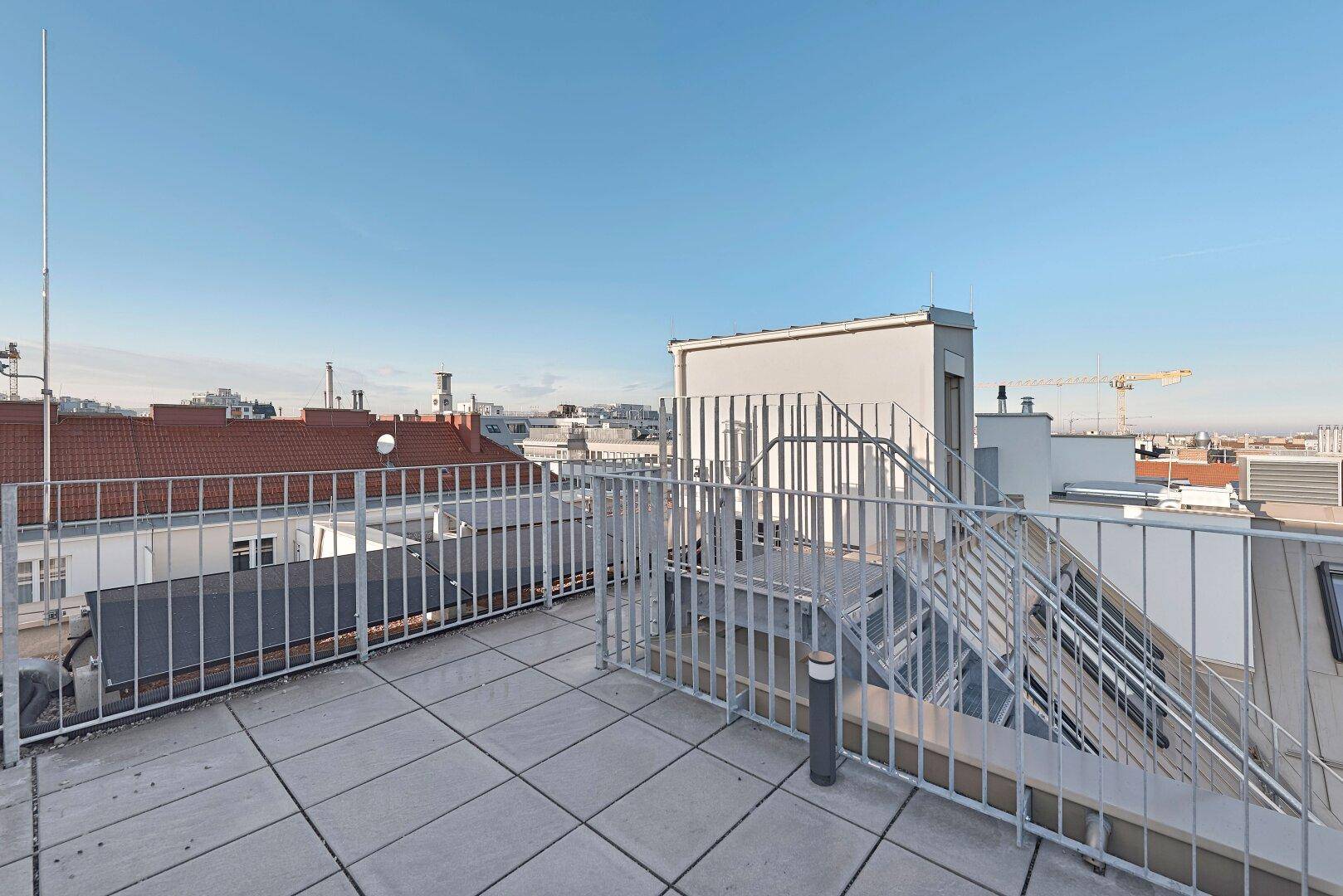 Große Dachterrasse mit weitem Blick über die Stadt und die umliegende Bebauung.