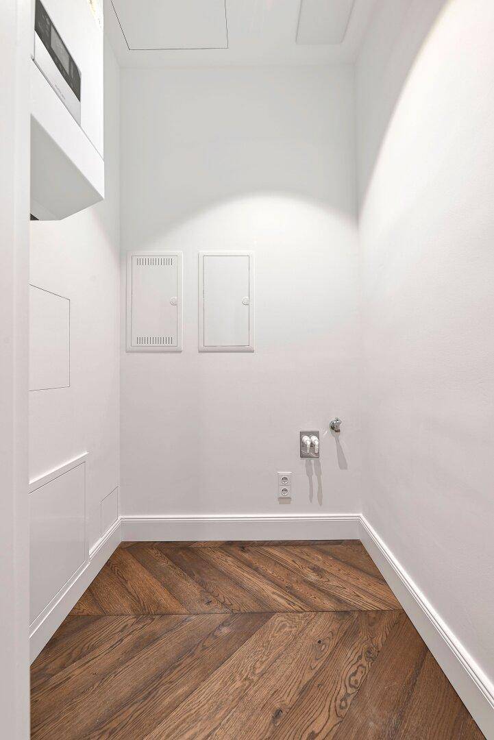 Kleiner Hauswirtschaftsraum mit Anschlüssen und Stauraum, ideal für Waschmaschine und Trockner.