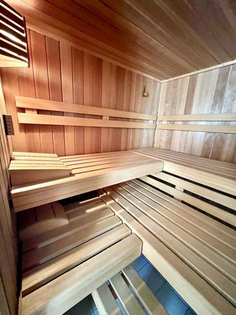 Innenansicht einer Holzsauna mit mehrstufigen Bänken und natürlicher Holzverkleidung.