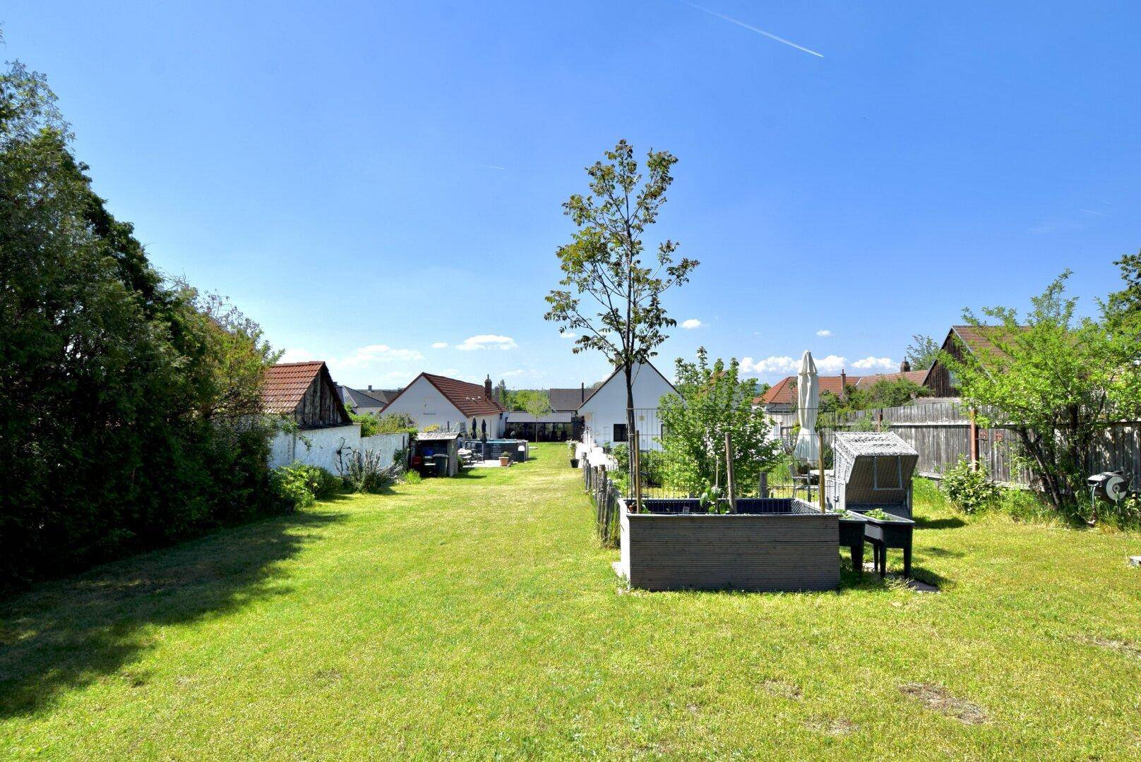 Weitläufiger Garten mit gepflegtem Rasen und Bäumen, der sich bis zum Horizont erstreckt.
