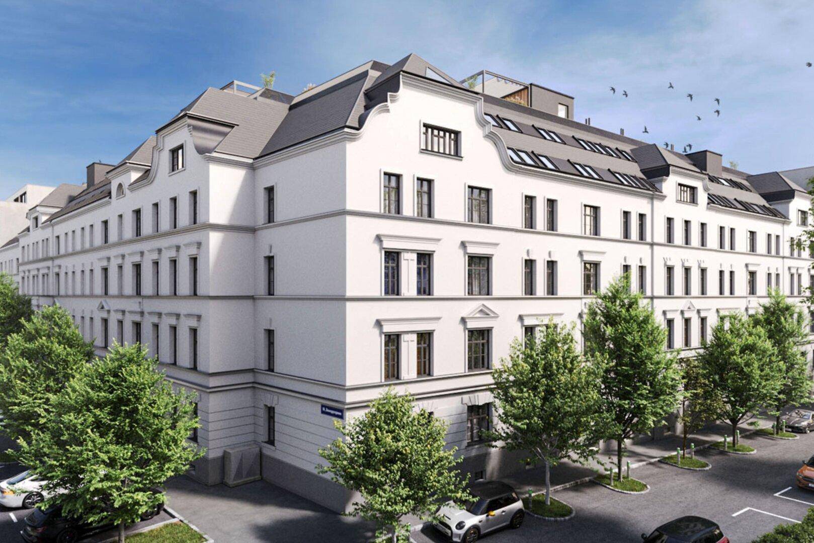Klassische Fassade eines eleganten Neubaus mit Mansarddach und vielen großen Fenstern.