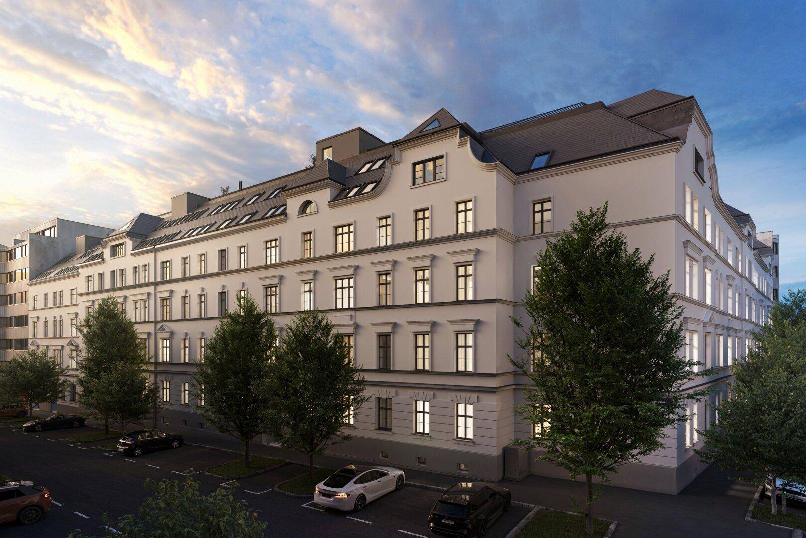 Historisches Gebäude mit klassischer Fassade und vielen Fenstern bei Sonnenuntergang.