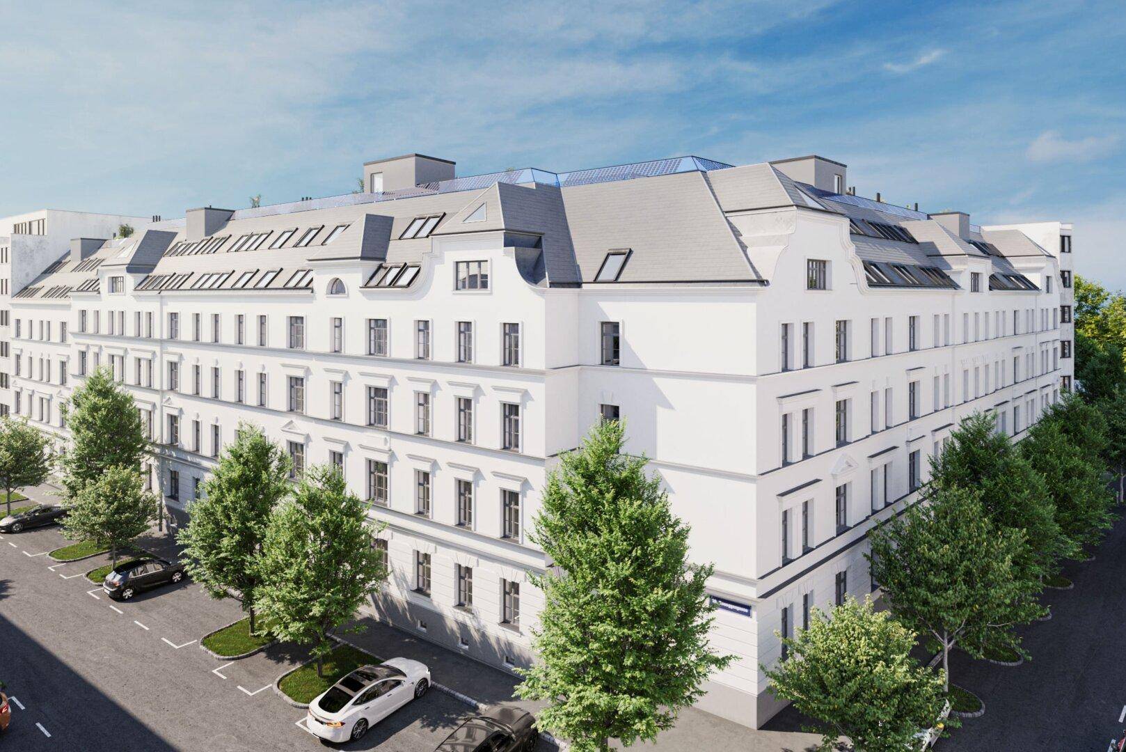 Elegante weiße Fassade eines Mehrfamilienhauses mit Satteldach und vielen Fenstern.