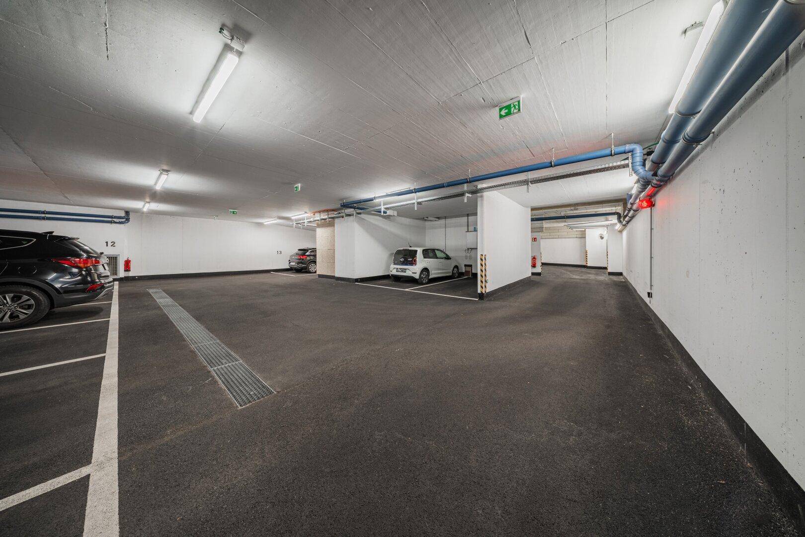Geräumige Tiefgarage mit markierten Stellplätzen und guter Beleuchtung.