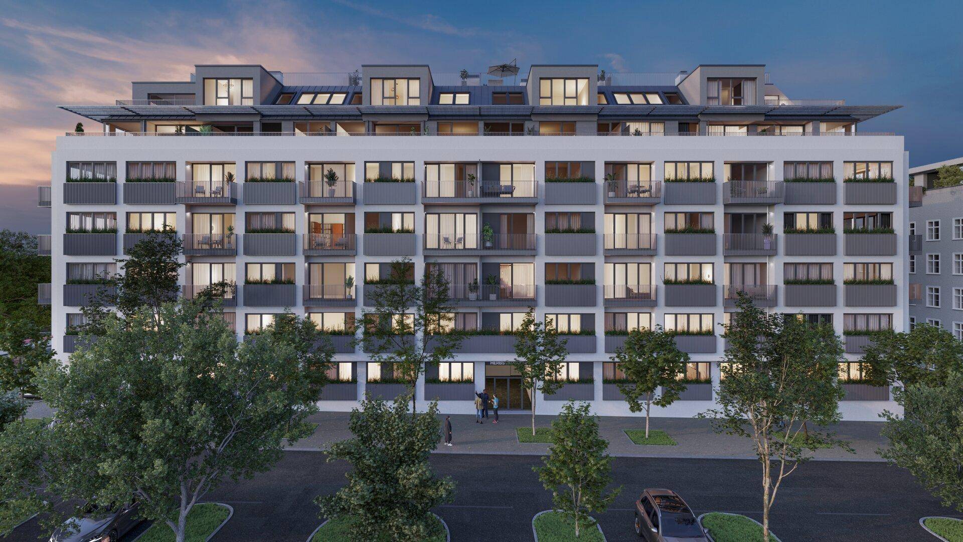 Moderne Wohnanlage mit mehreren Etagen, Balkonen und großen Fenstern bei Sonnenuntergang.
