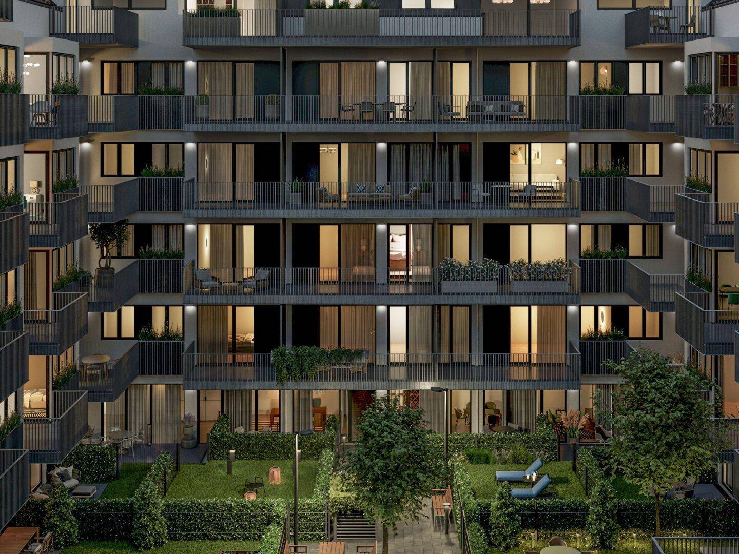 Moderne Wohnanlage bei Nacht mit beleuchteten Balkonen und einem begrünten Innenhof.
