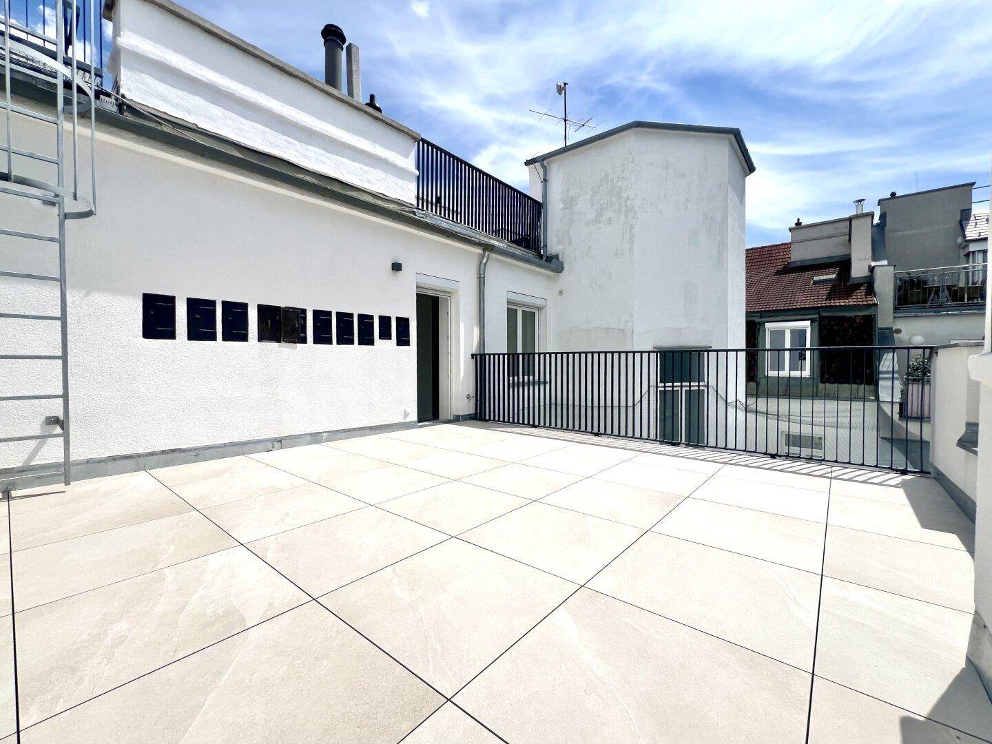Weitläufige Dachterrasse mit moderner Gestaltung und Zugang zu weiteren Bereichen.