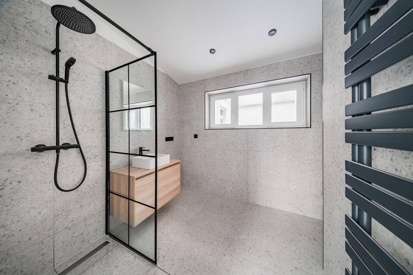 Modernes Badezimmer mit begehbarer Dusche, Einzelwaschbecken und Fenster.