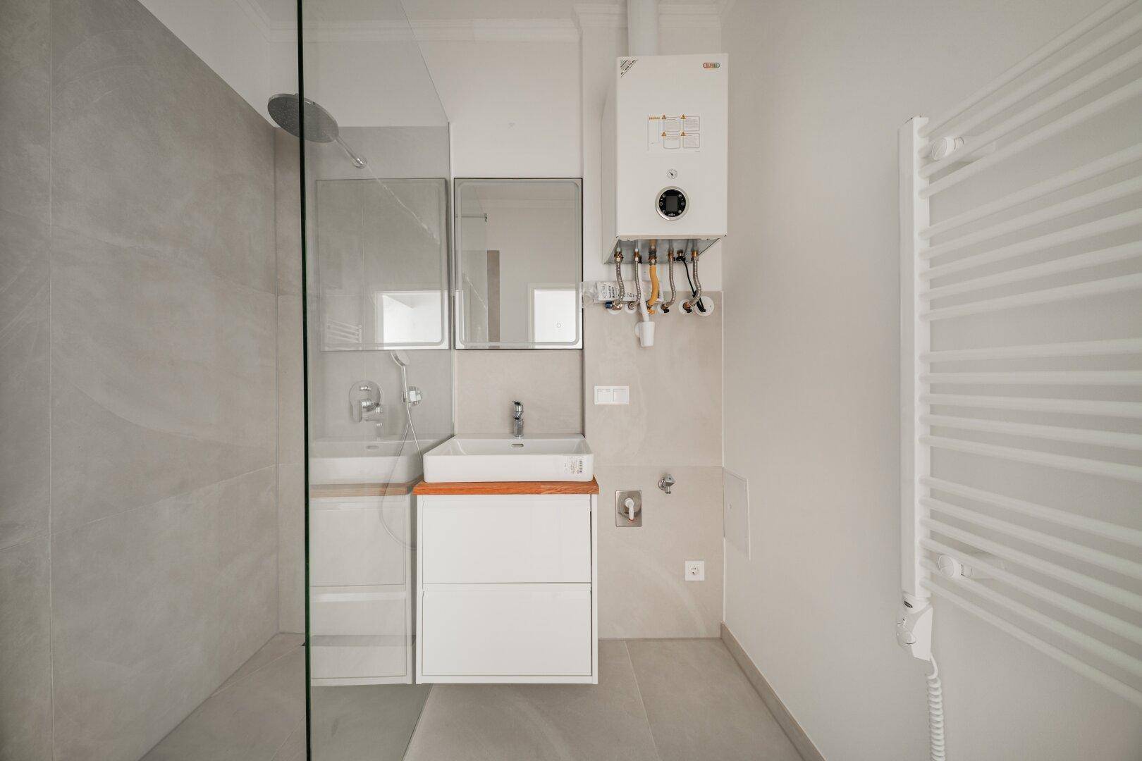 Helles Badezimmer mit moderner Ausstattung, Spiegelschrank und großzügiger Duschkabine.
