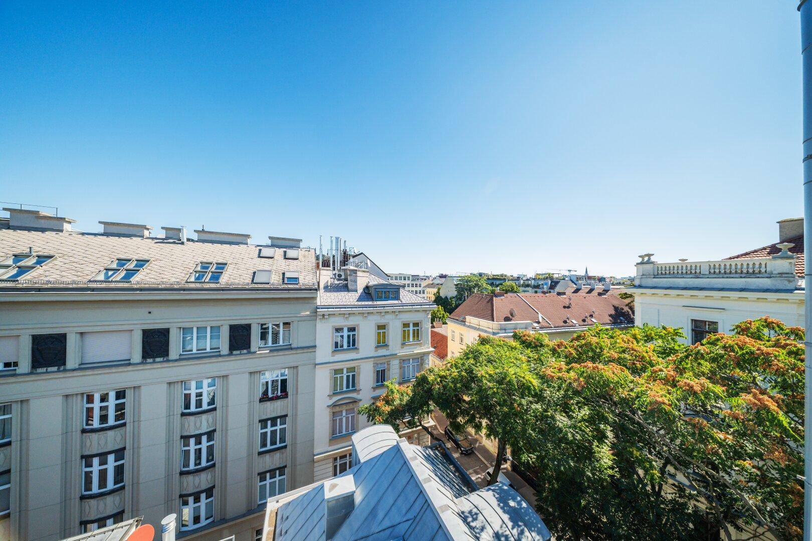 Panoramablick über die Dächer der Stadt mit umliegenden Gebäuden und blauem Himmel.