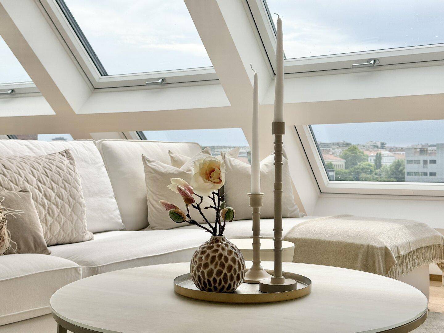 Detailansicht des Wohnzimmers mit Couch, Couchtisch und dekorativen Elementen.