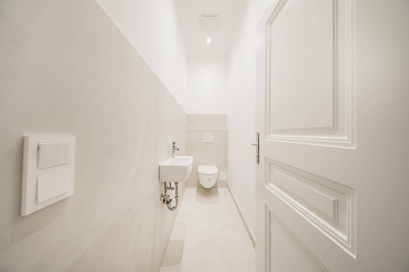 Kleines, modernes Gäste-WC mit wandhängendem WC und kompaktem Waschbecken.