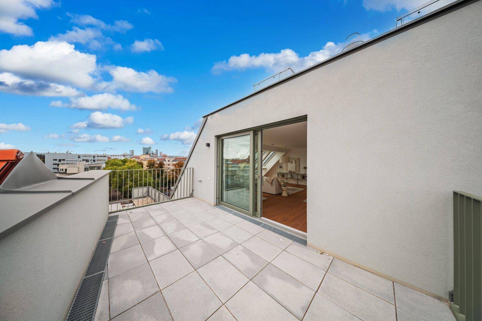 Geräumige Terrasse mit Fliesenboden und weitem Blick über die Stadt.