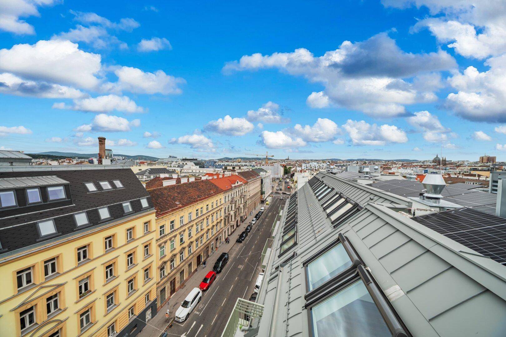 Panoramablick über die Stadt mit Dächern und einer belebten Straße.
