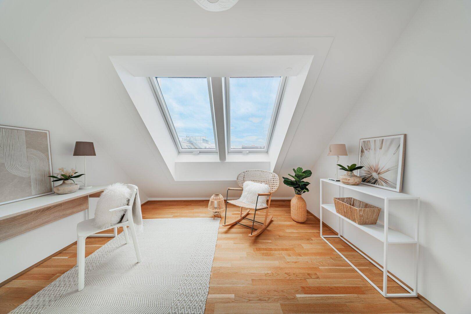 Helles Arbeitszimmer mit Holzboden, Dachschrägen und großen Dachfenstern für viel Tageslicht.