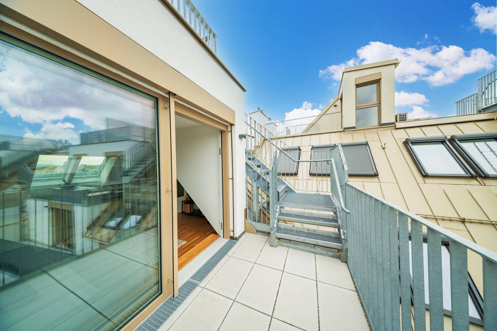 Dachterrasse mit Zugang zum Innenbereich und Blick auf die umliegenden Gebäude.