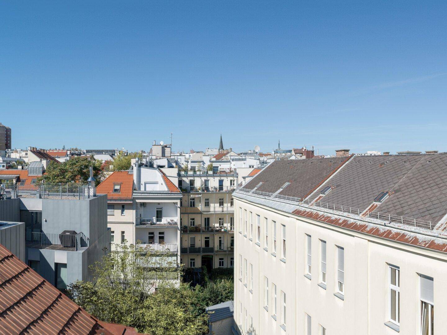 Panoramablick über die Dächer der Stadt mit traditionellen Gebäuden unter blauem Himmel.