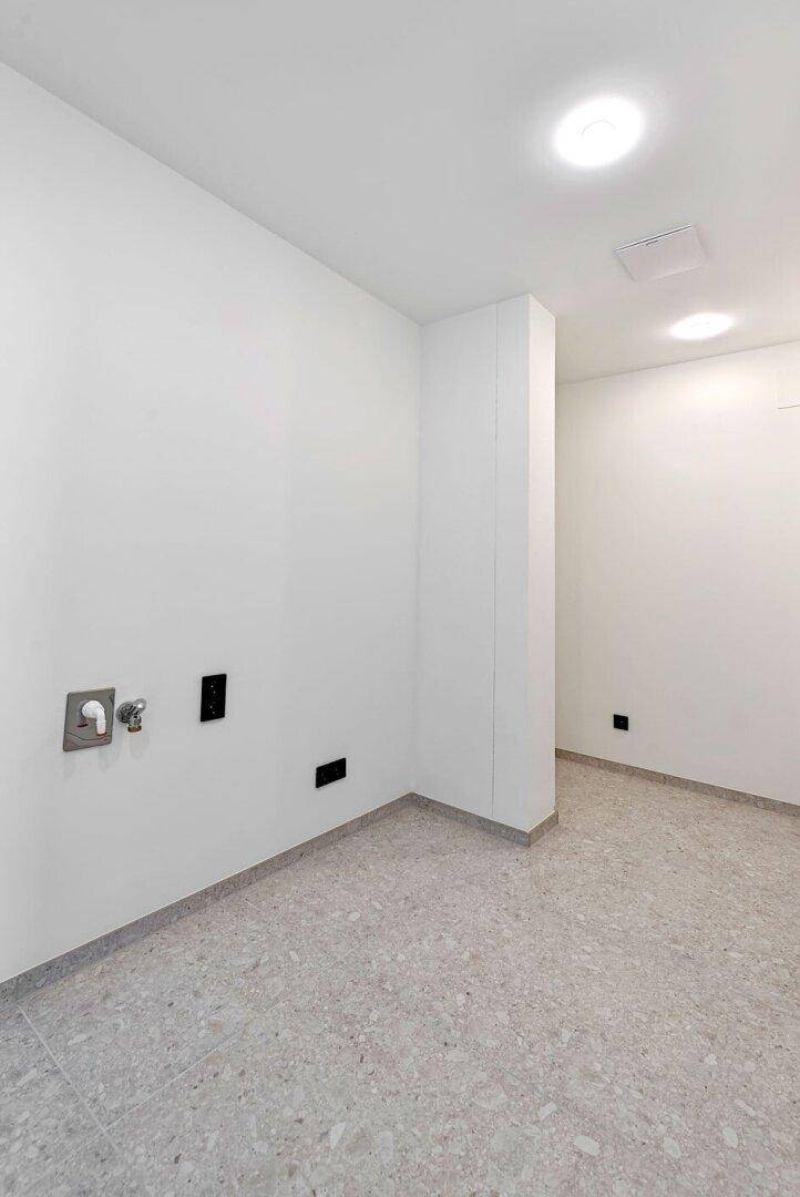 Praktischer Hauswirtschaftsraum mit Anschlüssen für Waschmaschine und Trockner.
