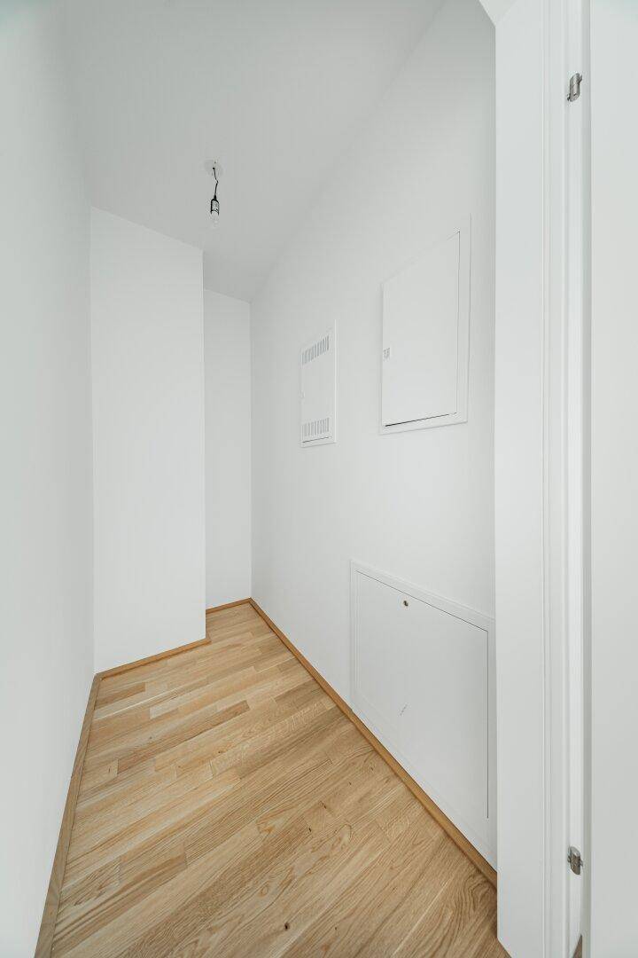 Kleiner Abstellraum mit Parkettboden und weißen Wänden, ideal für Lagerung und Haustechnik.