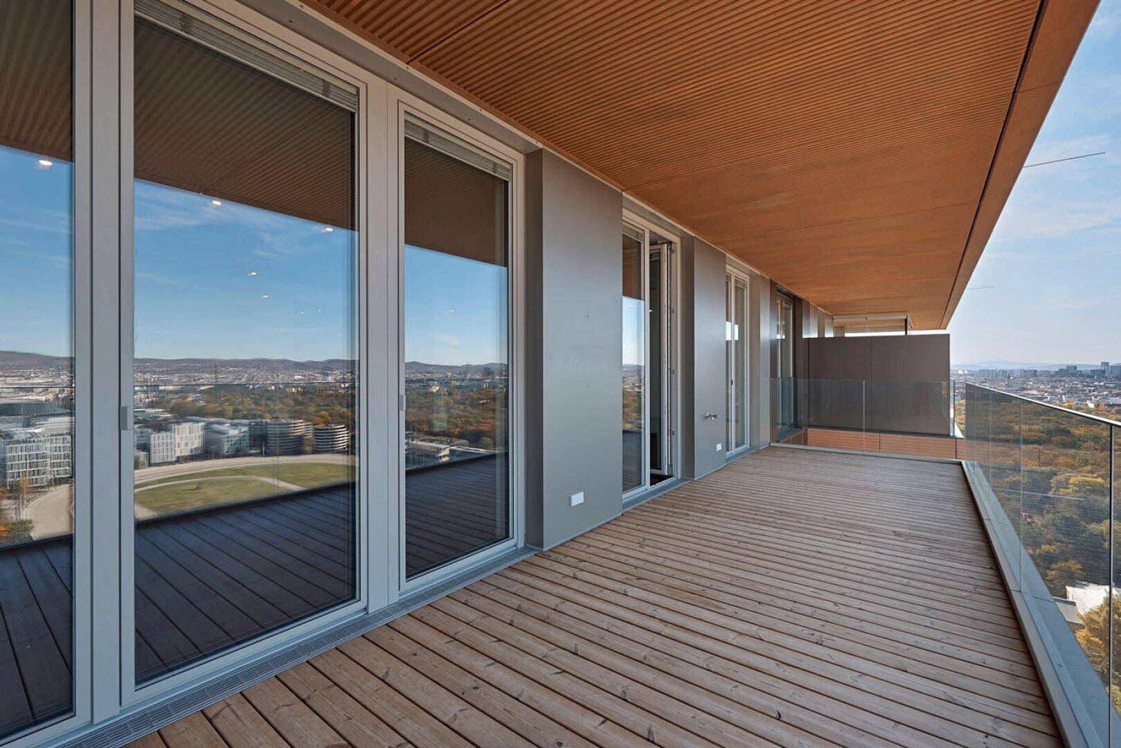 Weitläufige Holzterrasse mit Panoramablick über die Stadt und die umliegende Landschaft.