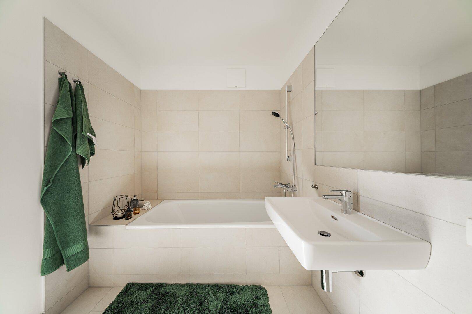 Zeitgemäßes Badezimmer mit Badewanne, schwebendem Waschbecken und großem Spiegel.