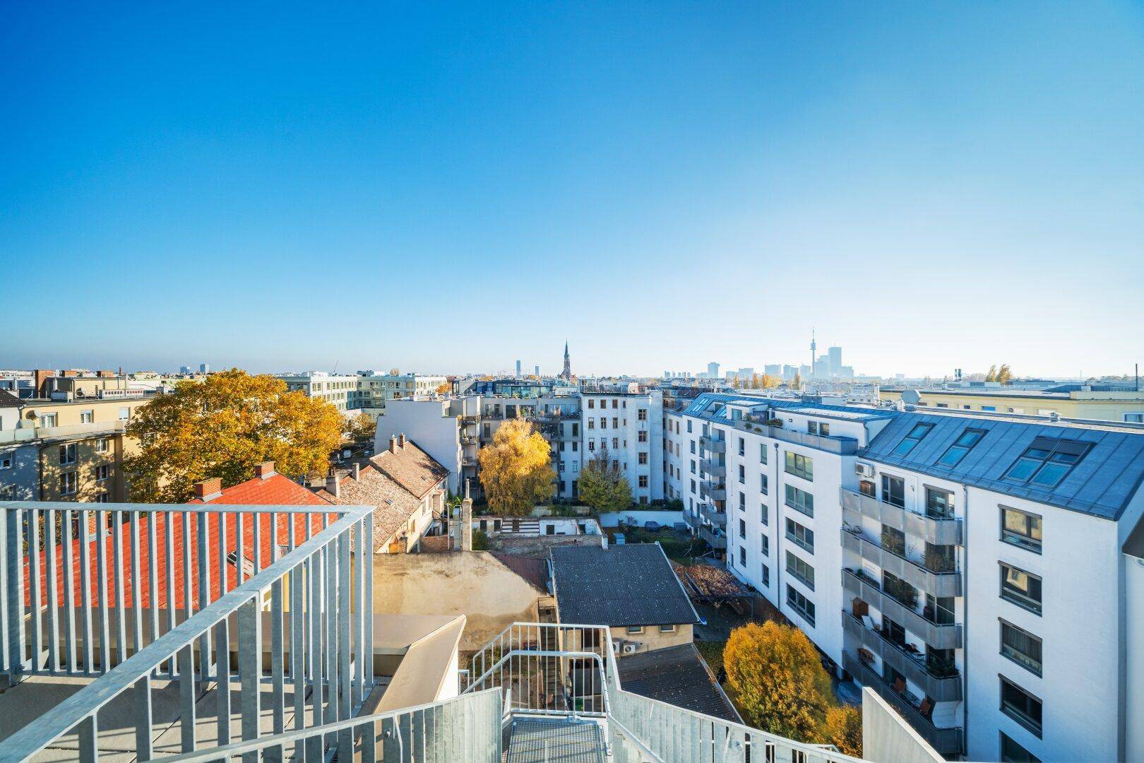 Dachterrasse mit weitem Blick über die Dächer der Stadt und die umliegende Bebauung.