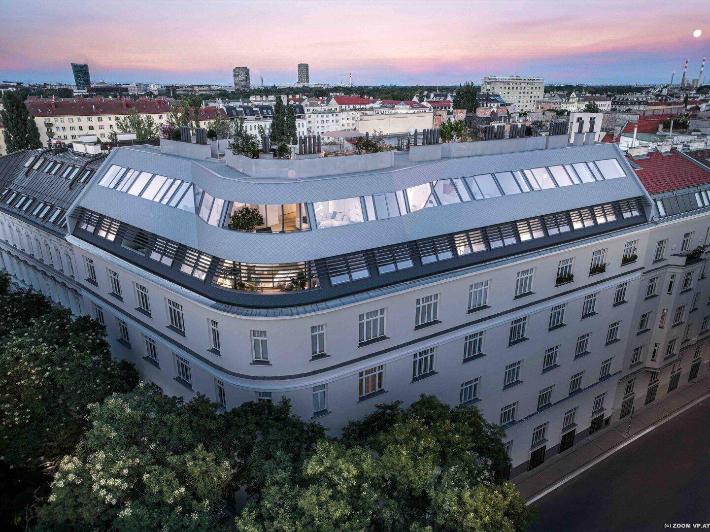 Architektonisch ansprechendes Gebäude mit Dachterrassen bei Sonnenuntergang in der Stadt.