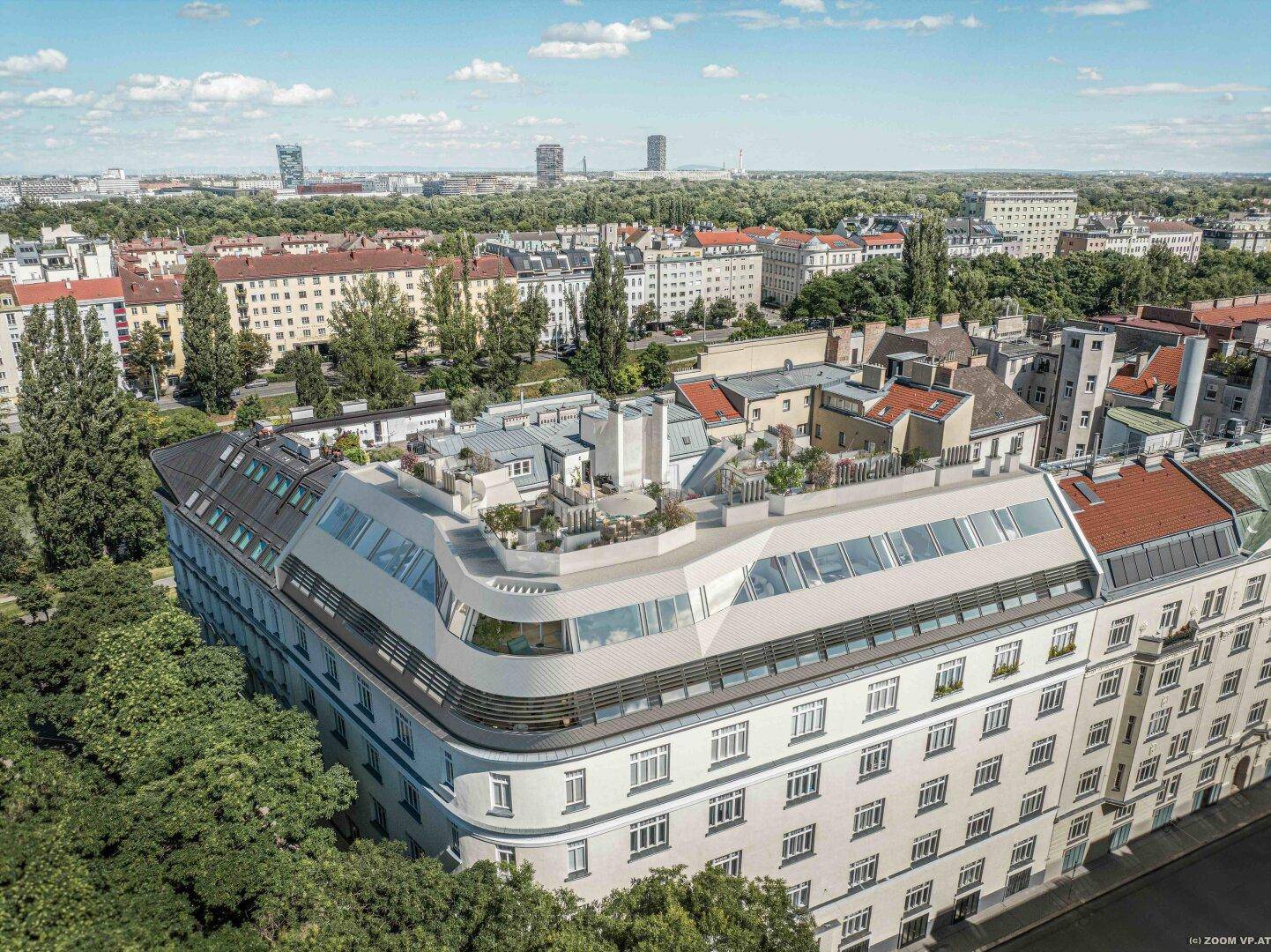 Vogelperspektive eines modernen Gebäudes mit Dachterrassen und urbaner Umgebung bei Tageslicht.