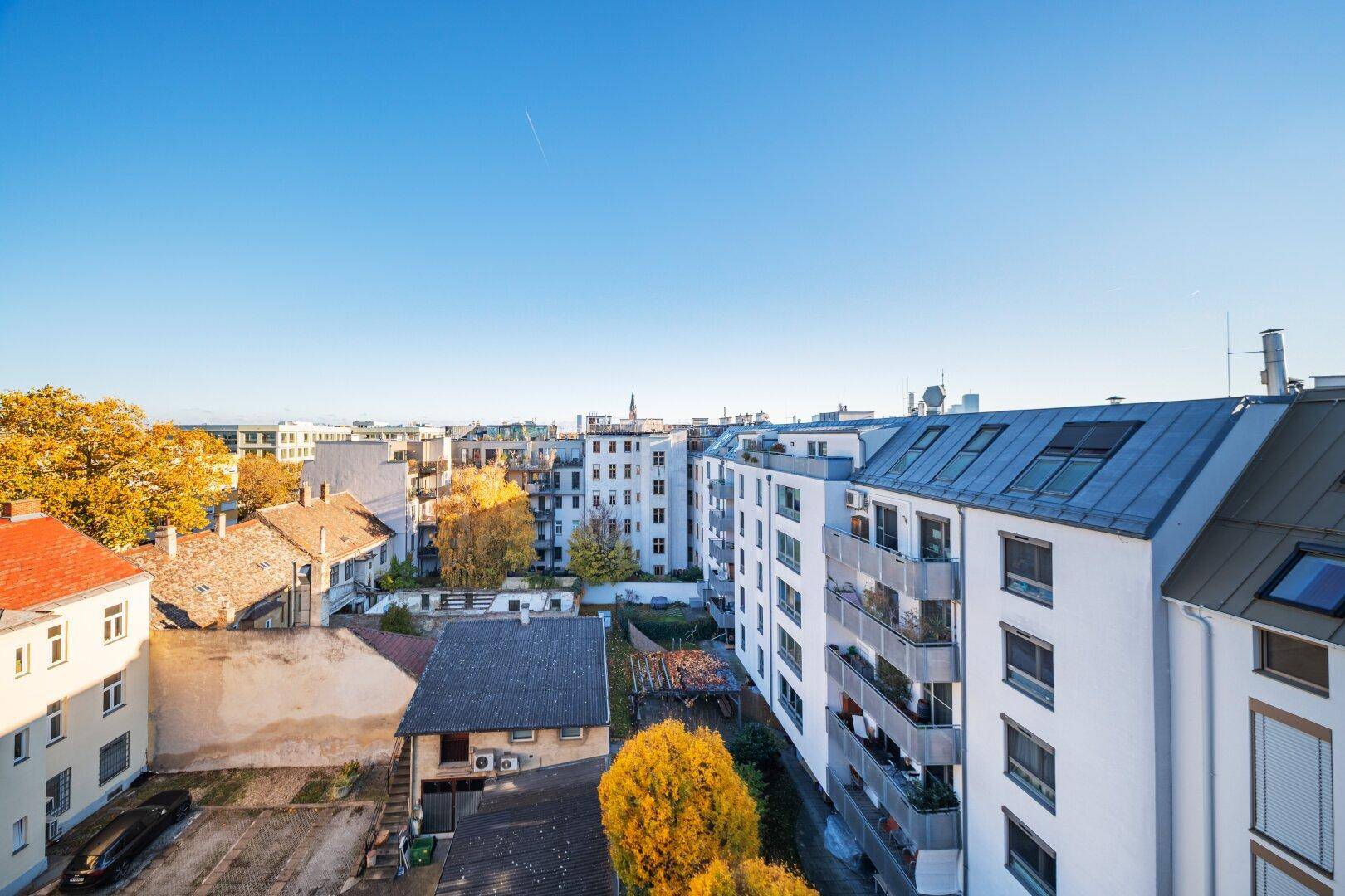 Panoramablick über die Dächer der Stadt mit umliegenden Gebäuden und Herbstbäumen.