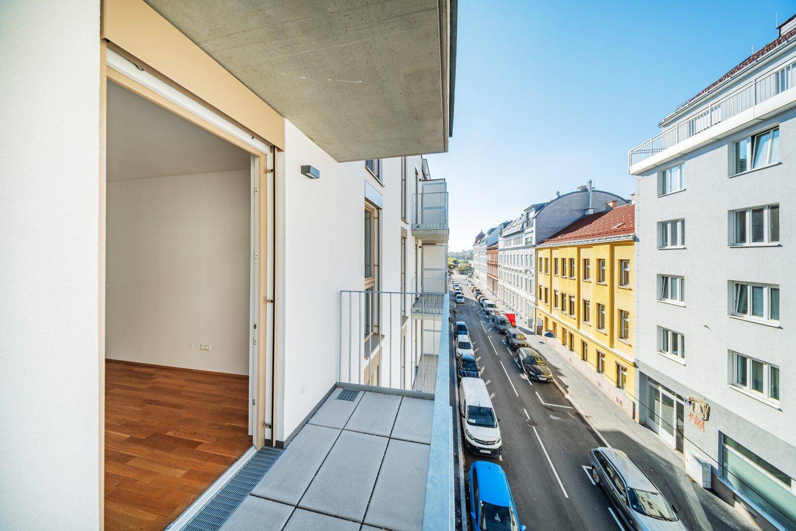 Balkon mit Blick auf die belebte Straße und die umliegenden Gebäude der Stadt.