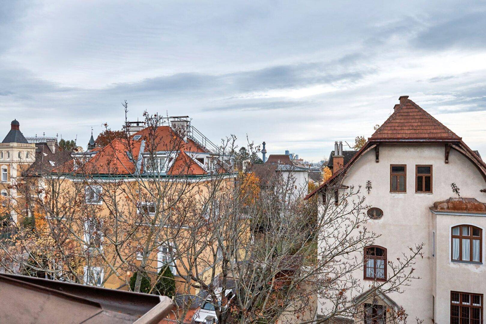 Weitläufiger Blick über eine historische Wohngegend mit vielfältiger Architektur und Bäumen im Herbstlaub.