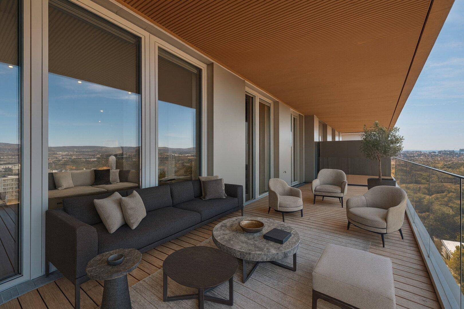 Großer, möblierter Balkon mit bequemen Sitzgelegenheiten und weitem Ausblick über die Stadt.