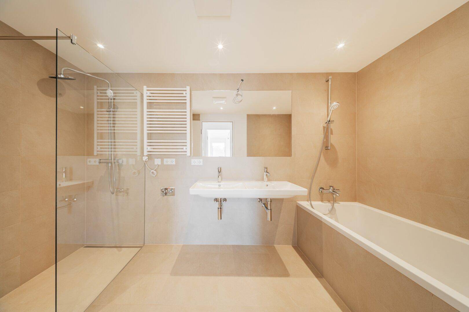 Modernes Badezimmer mit Doppelwaschbecken, Badewanne und begehbarer Dusche.