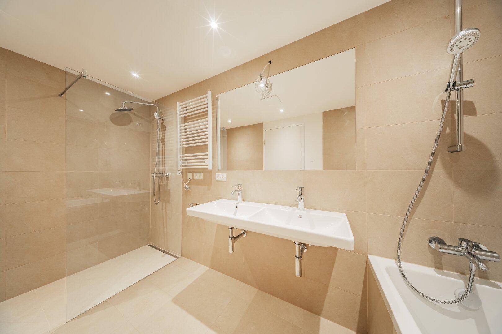 Modernes Badezimmer mit Doppelwaschbecken, Badewanne und begehbarer Dusche.